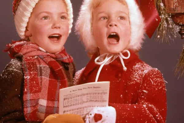 Two young children singing Christmas Carols from the 1960's