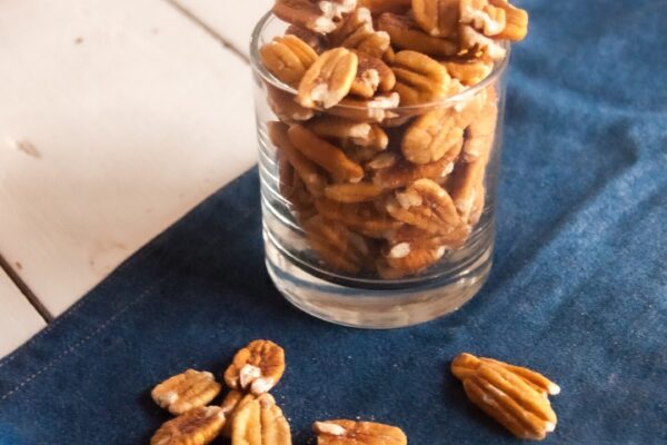 Image of pecans in a glass on a blue towel