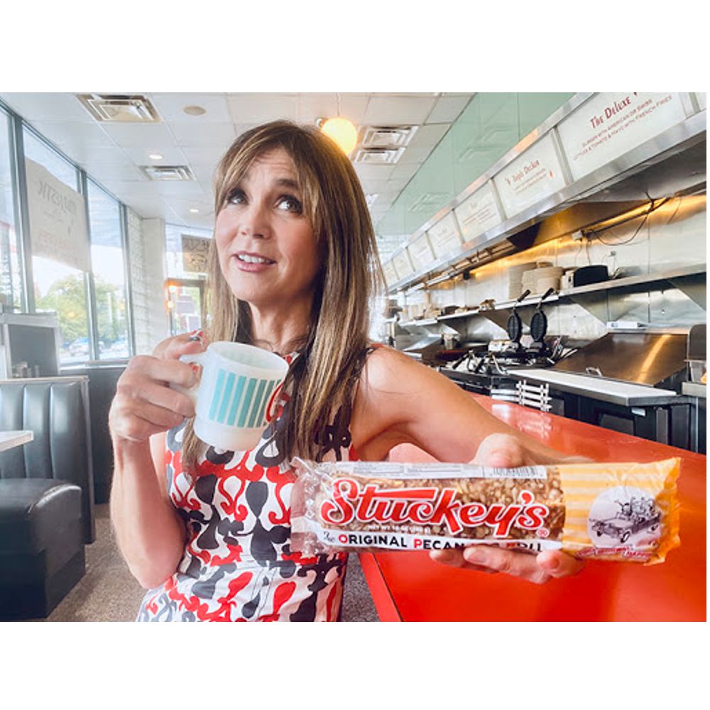 Image of Stephanie Stuckey holding a 10 oz. Pecan Log Roll in a grill