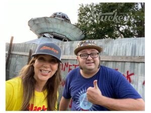 Photo of Stephanie Stuckey and Youtuber Jacob the Carpetbagger standing in front of the UFO Welcome House. 