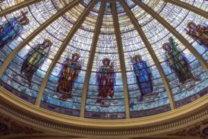 Photo of interior view of dome in the First Presbyterian Church in Orange Texas featuring various stained glass art of saints and angels.