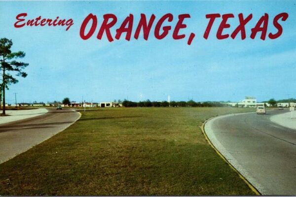 Picture postcard of Orange Texas traffic circle with the words entering Orange Texas written across the top.