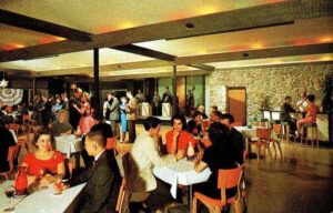 Picture postcard of dining room at Cove Haven resort with people dancing and eating circa 1960s.