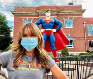 CEO Stephanie Stuckey posing with the Superman Statue in Metropolis Illinois.