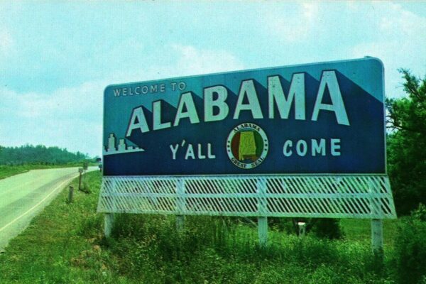 Photo postcard of a 1950s roadside welcome billboard for Alabama.