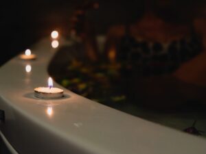 Picture of votive candles along rim of hot tub.