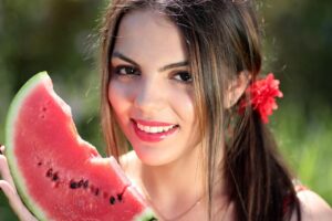 Photo of a girl holding a slice of watermelon.