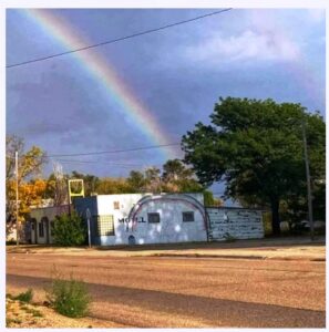 Picture of a rainbow cast over the rainbow of the Lazy U Motel.