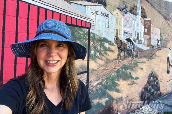 Stephanie Stuckey standing next to an Amish mural in Sarasota Fl